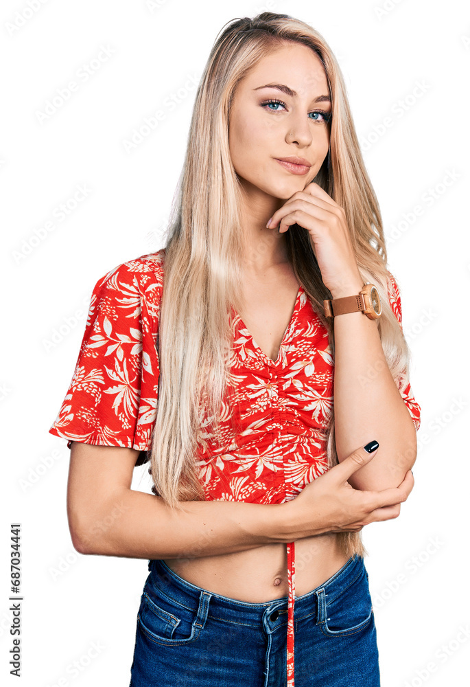 Wall mural Beautiful young blonde woman wearing summer shirt with hand on chin thinking about question, pensive expression. smiling and thoughtful face. doubt concept.