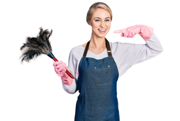 Beautiful young blonde woman wearing apron holding cleaning duster smiling cheerful showing and pointing with fingers teeth and mouth. dental health concept.