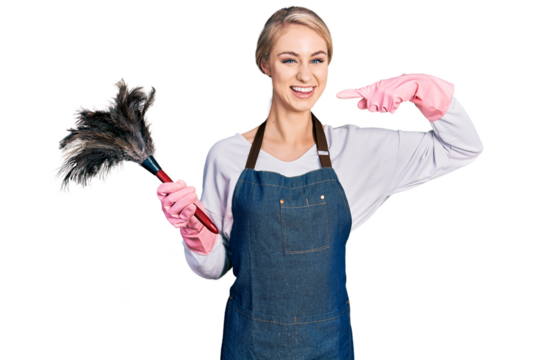 Beautiful young blonde woman wearing apron holding cleaning duster smiling cheerful showing and pointing with fingers teeth and mouth. dental health concept.