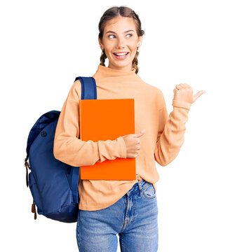Beautiful caucasian woman with blonde hair wearing student backpack and holding book pointing thumb up to the side smiling happy with open mouth