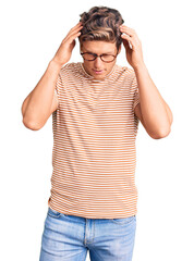 Fototapeta premium Young handsome man wearing casual clothes and glasses with hand on head for pain in head because stress. suffering migraine.