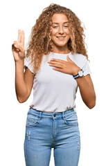 Beautiful caucasian teenager girl wearing casual white tshirt smiling swearing with hand on chest...