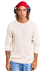 Young hispanic man listening to music using headphones depressed and worry for distress, crying angry and afraid. sad expression.