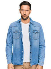 Young handsome man wearing casual denim jacket skeptic and nervous, frowning upset because of problem. negative person.