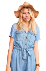 Young beautiful blonde woman wearing summer hat and dress depressed and worry for distress, crying angry and afraid. sad expression.