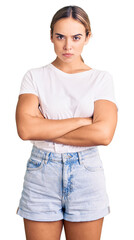 Obraz premium Young beautiful blonde woman wearing casual white tshirt skeptic and nervous, disapproving expression on face with crossed arms. negative person.