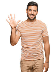 Handsome hispanic man wearing casual clothes showing and pointing up with fingers number five while smiling confident and happy.