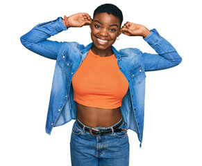 Young african american woman wearing casual clothes smiling pulling ears with fingers, funny...