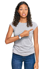 Young african american girl wearing casual clothes pointing aside worried and nervous with forefinger, concerned and surprised expression