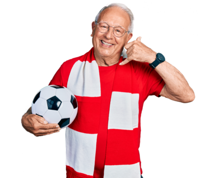 Senior man with grey hair football hooligan holding ball smiling doing phone gesture with hand and fingers like talking on the telephone. communicating concepts.