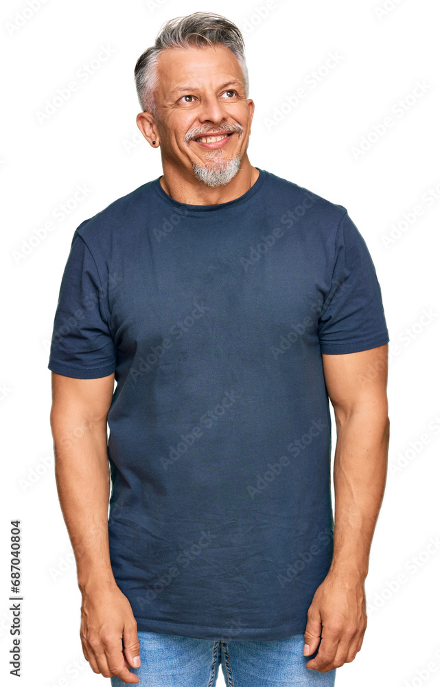 Sticker Middle age grey-haired man wearing casual clothes looking away to side with smile on face, natural expression. laughing confident.