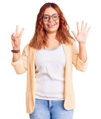 Young latin woman wearing business clothes showing and pointing up with fingers number seven while smiling confident and happy.