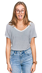 Obraz premium Beautiful young blonde woman wearing casual clothes and glasses sticking tongue out happy with funny expression. emotion concept.