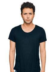 Obraz premium Young handsome man wearing casual black t shirt skeptic and nervous, frowning upset because of problem. negative person.