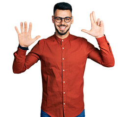 Fototapeta premium Young hispanic man with beard wearing business shirt and glasses showing and pointing up with fingers number eight while smiling confident and happy.