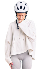 Beautiful brunette young woman wearing bike helmet and sporty clothes feeling unwell and coughing as symptom for cold or bronchitis. health care concept.
