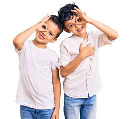 Naklejka premium Couple of little brothers together wearing casual clothes smiling happy doing ok sign with hand on eye looking through fingers