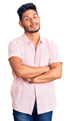 Handsome latin american young man wearing casual summer shirt happy face smiling with crossed arms looking at the camera. positive person.