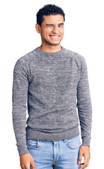 Hispanic handsome young man wearing casual sweater winking looking at the camera with sexy...