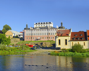 Fototapeta na wymiar The Sazava River and the town of Kacov with a brewery and a baroque castle on the river bank. Bohemia, Czech Republic