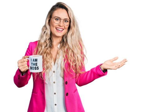 Young blonde woman drinking from i am the boss coffee cup celebrating achievement with happy smile and winner expression with raised hand