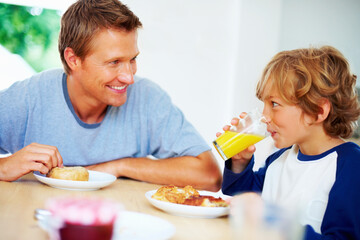 Happy family, morning and breakfast on weekend, looking and eating for nutrition, orange juice and donut. Father, child and enjoying food together for hunger, health and energy for good day