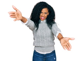 Middle age african american woman wearing casual clothes looking at the camera smiling with open arms for hug. cheerful expression embracing happiness.