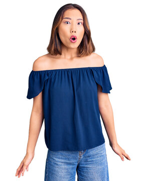 Young beautiful chinese girl wearing casual clothes afraid and shocked with surprise expression, fear and excited face.