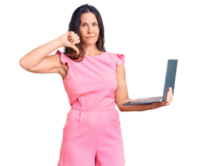 Young beautiful brunette woman working using laptop with angry face, negative sign showing dislike with thumbs down, rejection concept