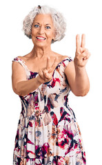 Senior grey-haired woman wearing casual clothes smiling looking to the camera showing fingers doing victory sign. number two.