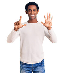 African handsome man wearing casual winter sweater showing and pointing up with fingers number seven while smiling confident and happy.