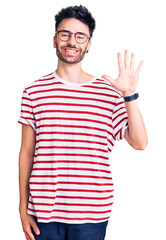 Naklejka premium Young hispanic man wearing casual clothes showing and pointing up with fingers number five while smiling confident and happy.