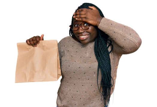 Young black woman with braids holding take away paper bag stressed and frustrated with hand on head, surprised and angry face