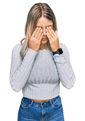 Beautiful blonde woman wearing casual clothes rubbing eyes for fatigue and headache, sleepy and...