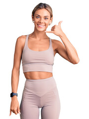 Beautiful caucasian woman wearing sportswear smiling doing phone gesture with hand and fingers like talking on the telephone. communicating concepts.