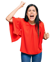 Beautiful young woman wearing casual clothes angry and mad raising fist frustrated and furious while shouting with anger. rage and aggressive concept.