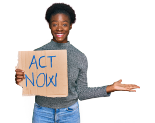 Young african american girl holding act now banner celebrating victory with happy smile and winner expression with raised hands