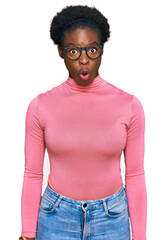 Young african american girl wearing casual clothes and glasses afraid and shocked with surprise expression, fear and excited face.