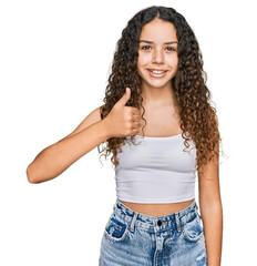 Teenager hispanic girl wearing casual clothes doing happy thumbs up gesture with hand. approving expression looking at the camera showing success.