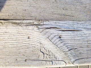 The wall of old boards natural wood. Weathered planks with a diagonal pattern. The tree darkened under the sun.