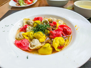 Colored dumplings are on a plate in a restaurant. Food for children