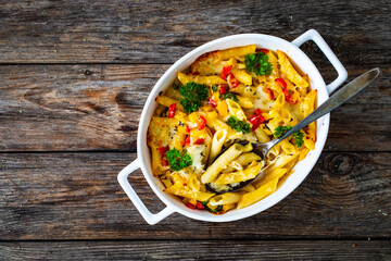 Noodle casserole with mozzarella cheese and vegetables on wooden table
