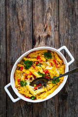 Noodle casserole with mozzarella cheese and vegetables on wooden table
