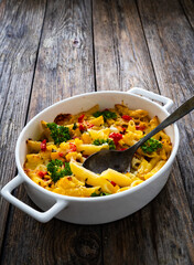 Noodle casserole with mozzarella cheese and vegetables on wooden table
