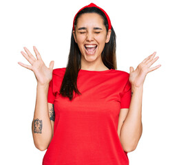 Young hispanic woman wearing casual clothes celebrating mad and crazy for success with arms raised...