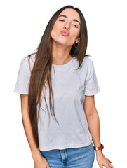 Obraz premium Young hispanic girl wearing casual white t shirt looking at the camera blowing a kiss on air being lovely and sexy. love expression.