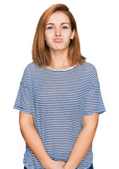 Fototapeta premium Young caucasian woman wearing casual clothes puffing cheeks with funny face. mouth inflated with air, crazy expression.