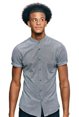 African american man with afro hair wearing casual clothes smiling looking to the side and staring...