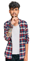 Young hispanic man wearing casual clothes asking to be quiet with finger on lips. silence and...