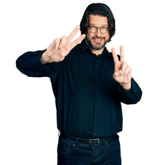 Middle age caucasian man wearing casual clothes and glasses smiling looking to the camera showing fingers doing victory sign. number two.